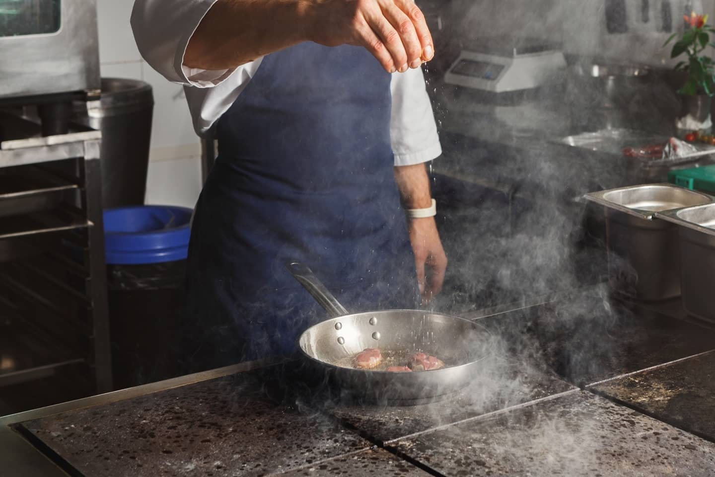 Würzen von Fleisch in der Pfanne