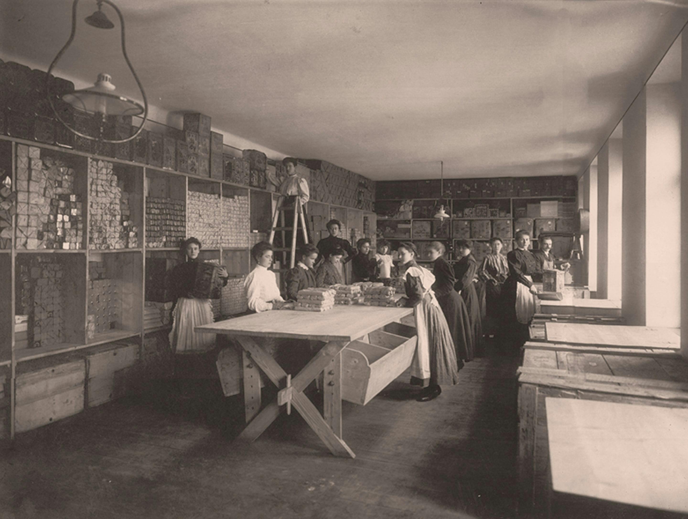Czarno-biała fotografia: pracownicy pakujący mieloną paprykę Kotányi w 1881 r.